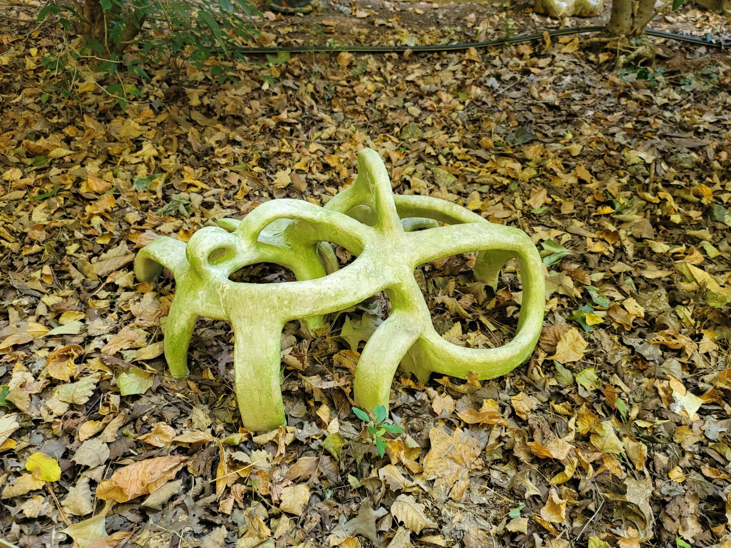 Green-yellow abstract sculpture with yellow and brown leaves