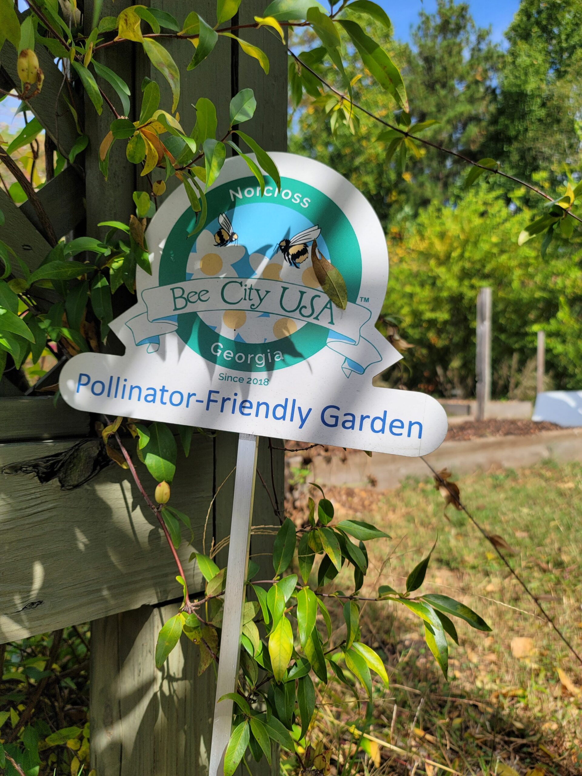 A small Bee City sign reading "Pollinator-Friendly Garden."