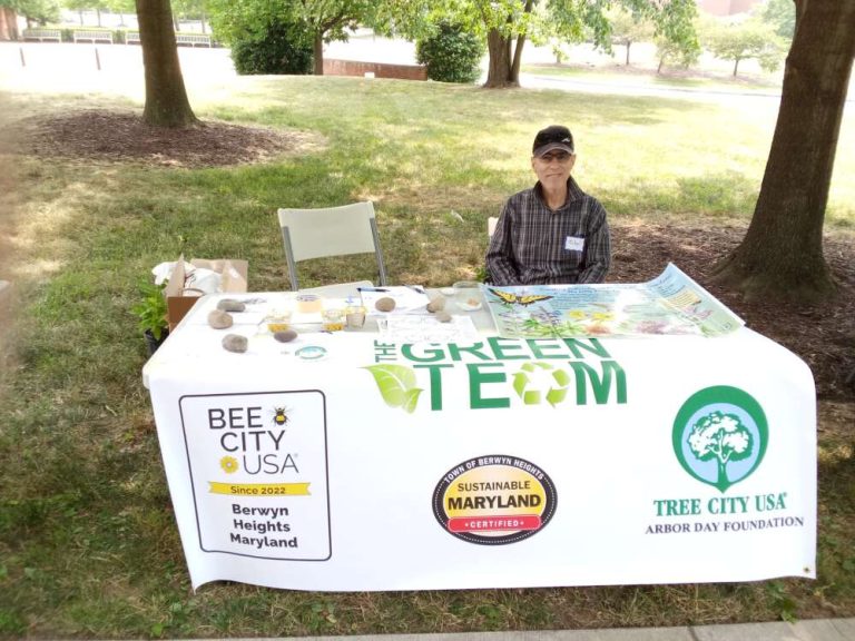 A person sits outside at a table with a white display cloth.