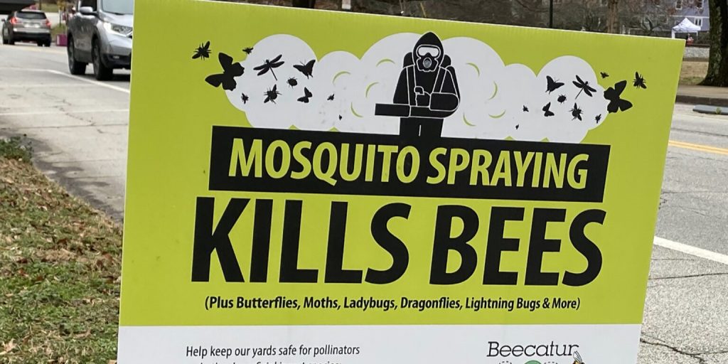 Lime green, black and white yard sign reading: "mosquito spraying kills bees".