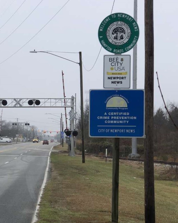 Picture of a three street signs next to a large road.