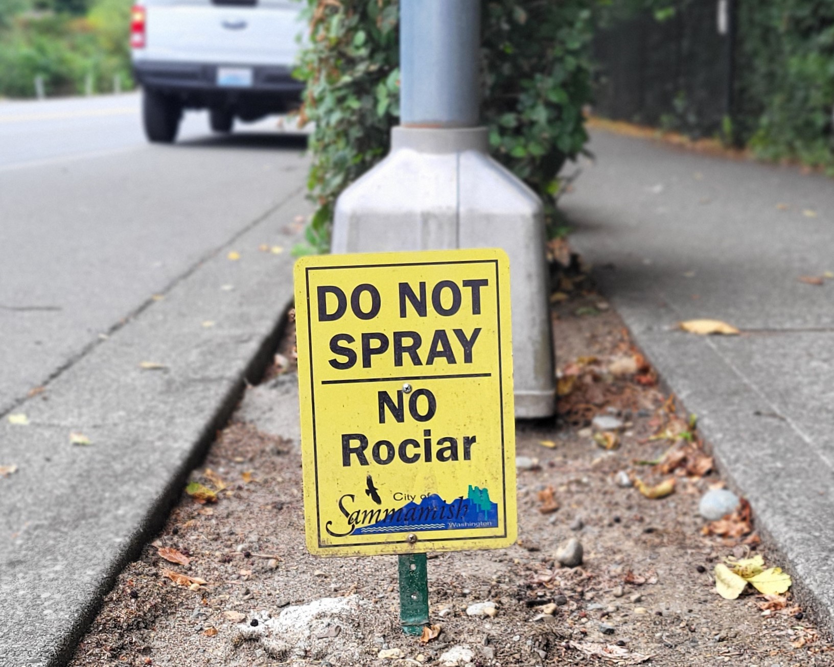 A small sign next to a road reads "Do not spray, No Rociar".