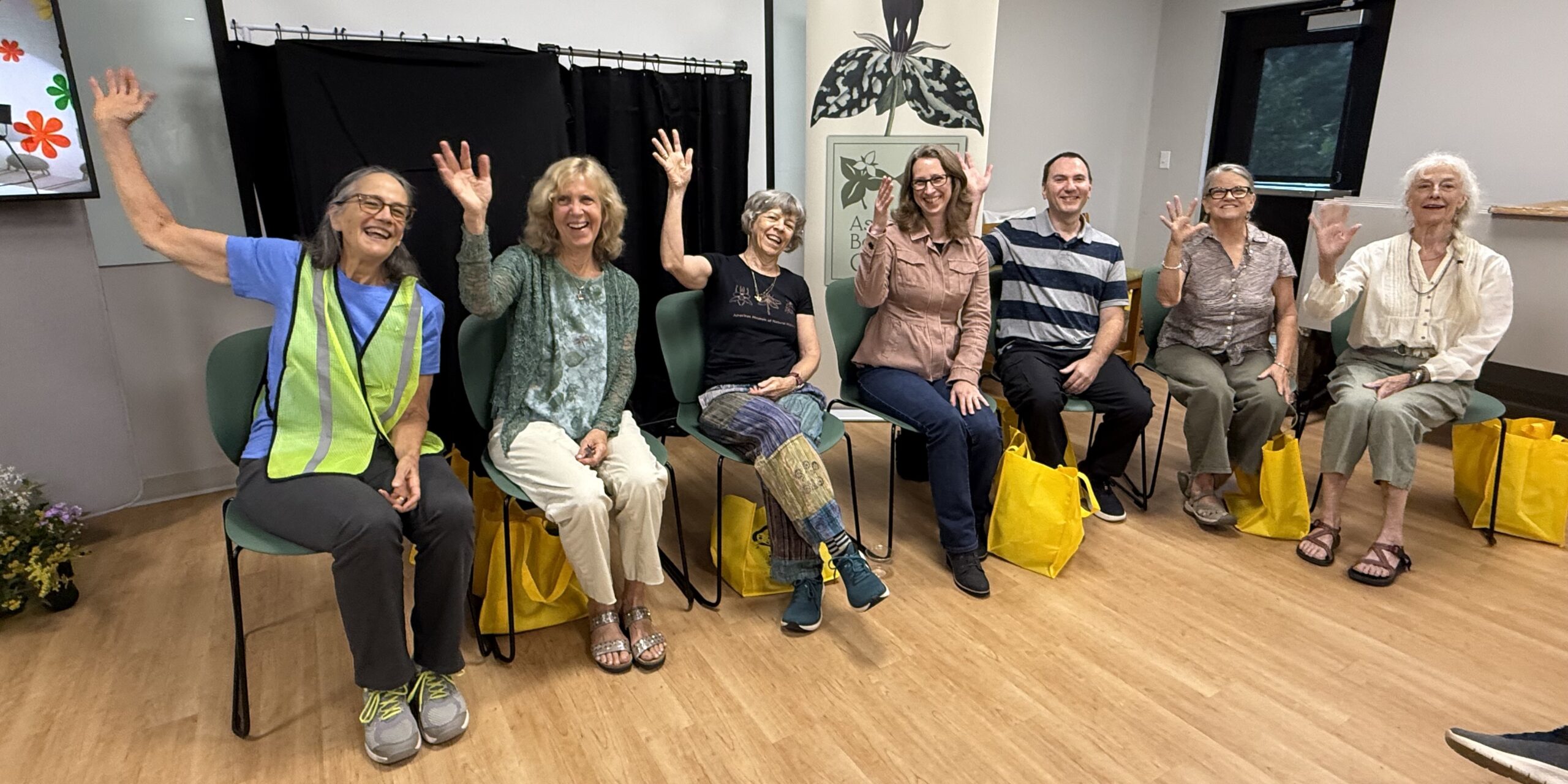 A row of seated people raising their right hands.