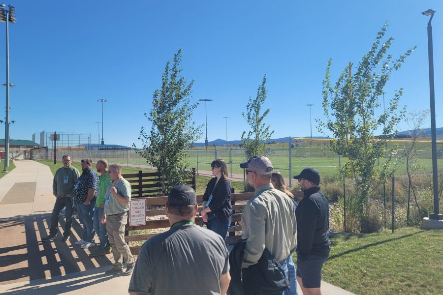 A group of people stand near a park.