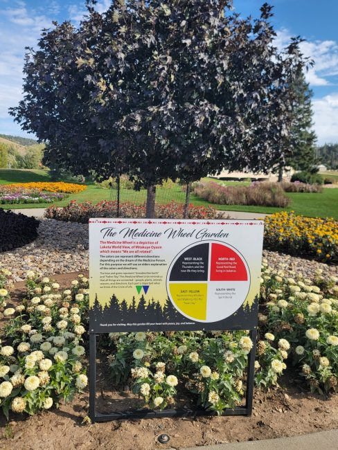 A flowering garden with a sign.