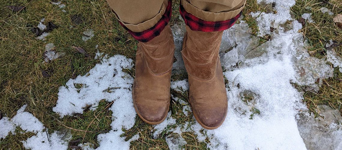 Brown boots on snow covered grass